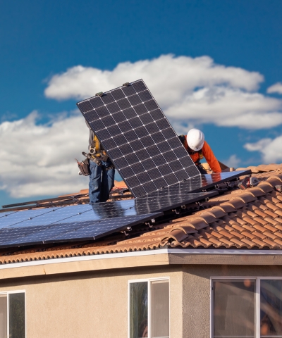 Instalación profesional de placas solares en tejado de vivienda con técnicos especializados.